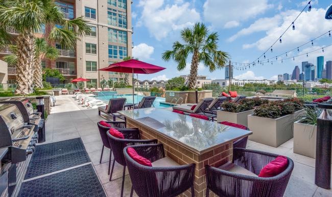 The essence of exceptional living a patio with chairs and tables and umbrellas and buildings in the background
